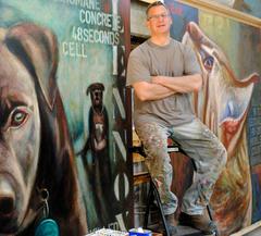Mark Baron in front of paintings